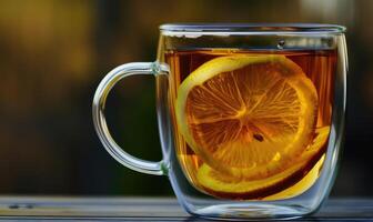 Bergamot tea and fresh lemon in a clear glass cup photo