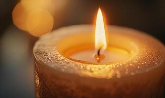 Close-up of a flickering candle flame casting a warm glow photo