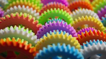 Looping 3D animation of a group of multi-colored plastic toy gears. Close-up. Defocus video