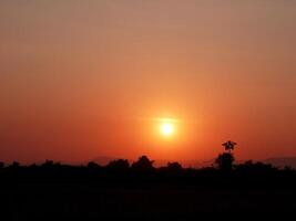 Spectacular sunset over, orange sun rising up over the horizon photo