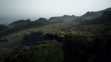 un brumoso ver de un rocoso montaña rango. montaña camino video