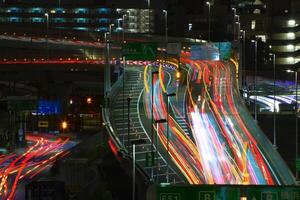 un noche lapso de tiempo de el tráfico mermelada a el urbano calle en tokio largo Disparo foto