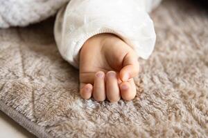 A left hand of sleeping asian baby on the carpet photo