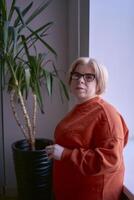 portrait of a woman with a disability in an orange sweater and leather pants in the office photo