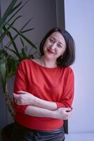 portrait of a brunette with a bob haircut in a red sweater and a leather mini skirt in the office photo