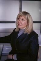 portrait of a blonde middle age woman in a business suit in the office photo