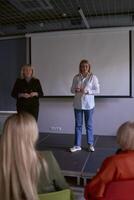 two middle age women in business suits on stage in the office photo