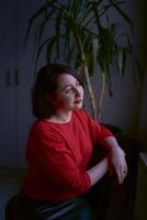 portrait of a brunette with a bob haircut in a red sweater and a leather mini skirt in the office photo