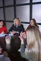 medio años mujer sonriente a un reunión en el oficina foto