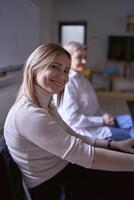 a woman smiles at the camera at a meeting in the office photo