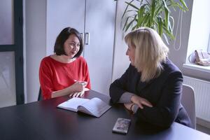 dos mujer discutir estrategia en el oficina foto