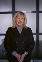 portrait of a blonde middle age woman in a business suit in the office photo