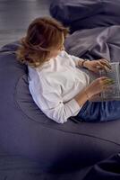 a woman in casual clothes is sitting at a laptop on bean bag in front of a panoramic window with a view of the city, green screen, Chroma key photo