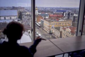 un ver de el ciudad desde un moderno lugar de trabajo, un mujer en el primer plano foto