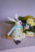 flores y un Conejo mentira en un de madera estar de un florista en un mesa Hasta que ellos son hecho dentro un flor arreglo para Pascua de Resurrección foto