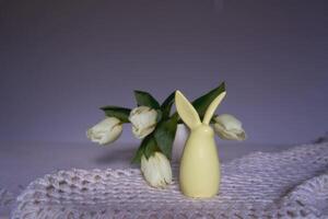 minimalista tulipanes en un mesa con un Pascua de Resurrección conejito foto