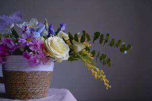 Easter floral arrangement with two blue Easter bunnies in a wicker basket photo