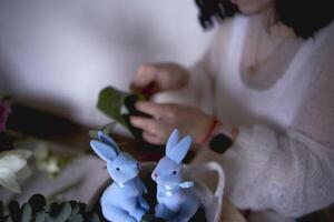 hembra florista hacer decoraciones y floral preparativos para Pascua de Resurrección foto