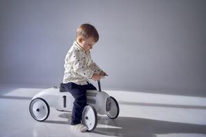 un niñito es con entusiasmo jugando con su juguete coche en su cumpleaños foto