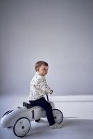 A toddler is enthusiastically playing with his toy car on his birthday photo