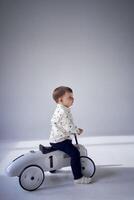 A toddler is enthusiastically playing with his toy car on his birthday photo