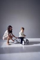 emotional mother playing with her little son and his toy car photo