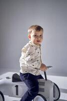 A toddler is enthusiastically playing with his toy car on his birthday photo
