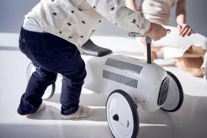 A toddler is enthusiastically playing with his toy car on his birthday photo