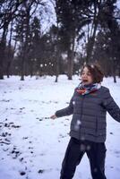 mujer jugar con nieve en bosque foto