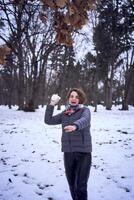 mujer jugar con nieve en bosque foto