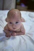 cuatro meses antiguo bebé laico en el cama foto