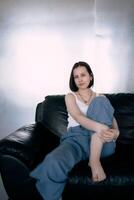 young teenage girl fighting brain cancer at photo shoot in studio, metal wall, reflection, black sofa