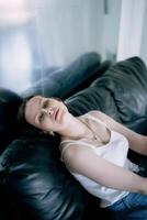 young teenage girl fighting brain cancer at photo shoot in studio, metal wall, reflection, black sofa