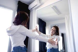 joven Adolescente niña luchando cerebro cáncer mira a su reflexión en el espejo, un metáfora para el vida futura foto
