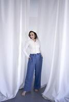 young teenage girl fighting brain cancer in a studio photo shoot, white curtains surround the girl, purity, innocence, minimalism