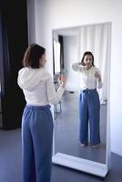 young teenage girl battling brain cancer looks at her reflection in the mirror, a metaphor for the afterlife photo
