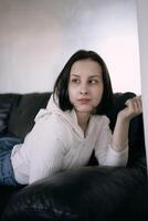 young teenage girl fighting brain cancer at photo shoot in studio, metal wall, reflection, black sofa