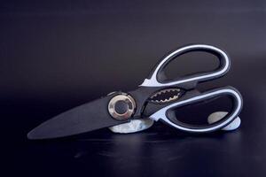 kitchen scissors in a protective case on a black background photo