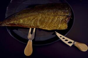 the  process of dissecting hot smoked golden horse mackerel with small knives photo