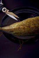 the  process of dissecting hot smoked golden horse mackerel with small knives photo