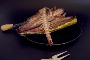 the  process of dissecting hot smoked golden horse mackerel with small knives photo