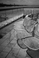 rows of metal chairs on the pier photo