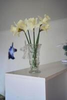 daffodils in a crystal vase on a shelf photo