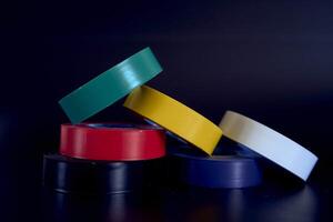 conjunto de de colores aislante cinta en un negro antecedentes foto