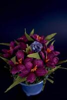 amethyst ring and a pendant of paper flowers in a blue vase on a black background photo