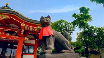 Wakabayashi Inari Shrine fox fox and red shrine building.Wakabayashi Inari Shrine is a shrine in Setagaya Ward, Tokyo. Since it received a donation of shrine territory in 1769, it is presumed photo