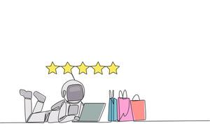 Single continuous line drawing young astronaut on stomach while typing on laptop. Next to the laptop is shopping bag. Give the best review with pleasure. Spaceman. One line design illustration vector