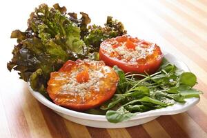 leafy salad with tomatoes stuffed with red pepper jam photo