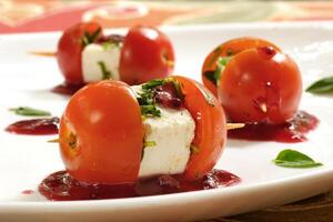 cherry tomato canape with cheese and strawberry jam on plate photo