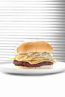 goat meat burger with cheese and caramelized onions on a plate photo